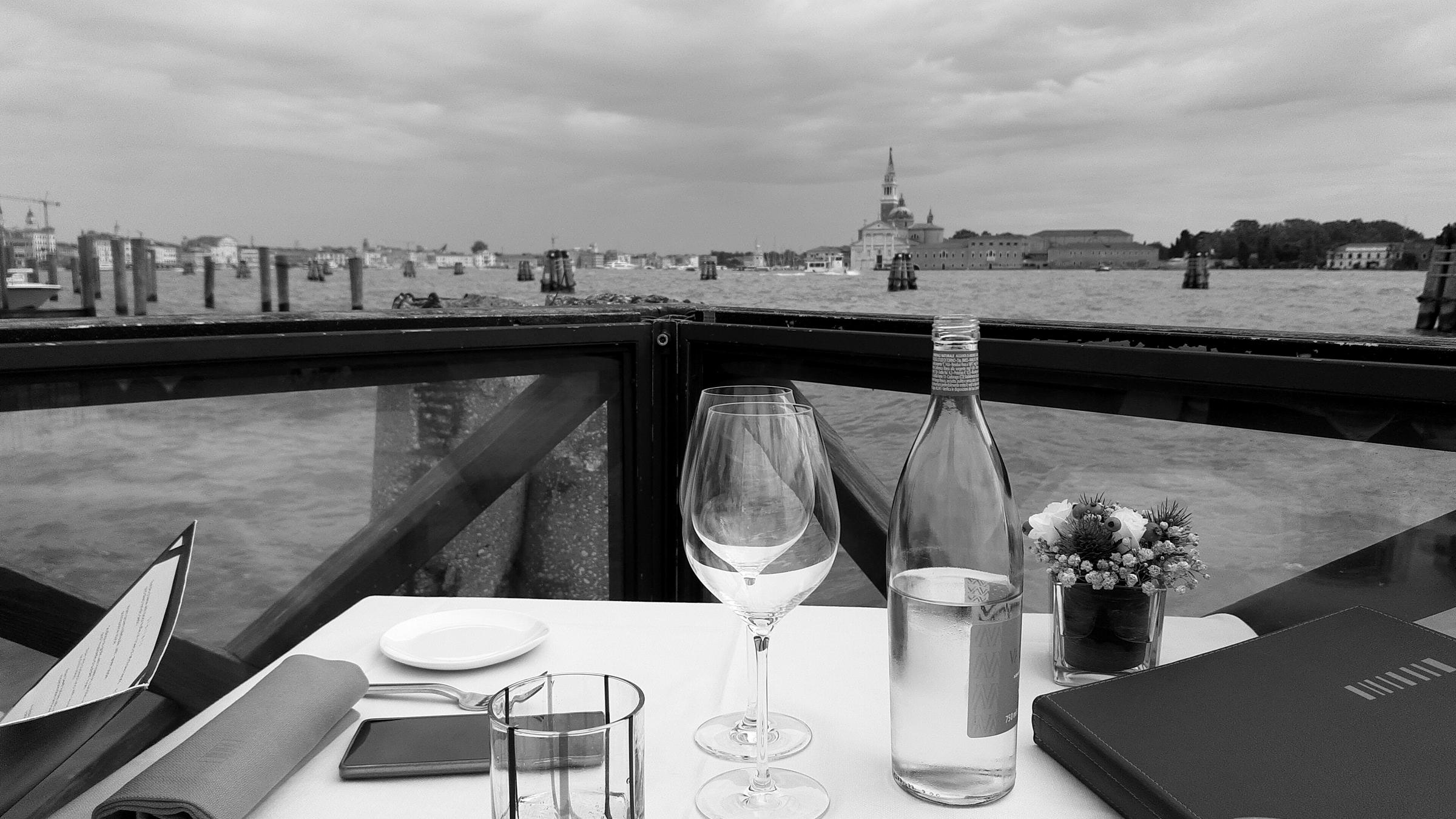 A table set on a terrace over the water in Venice